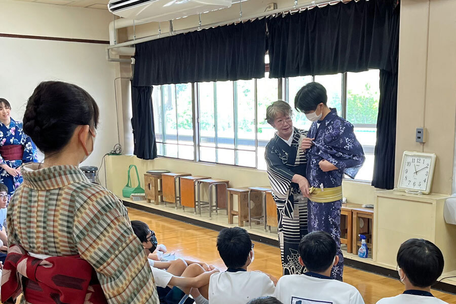 ゆかたの着方のデモンストレーション-講師が浴衣の帯結びを説明している場面